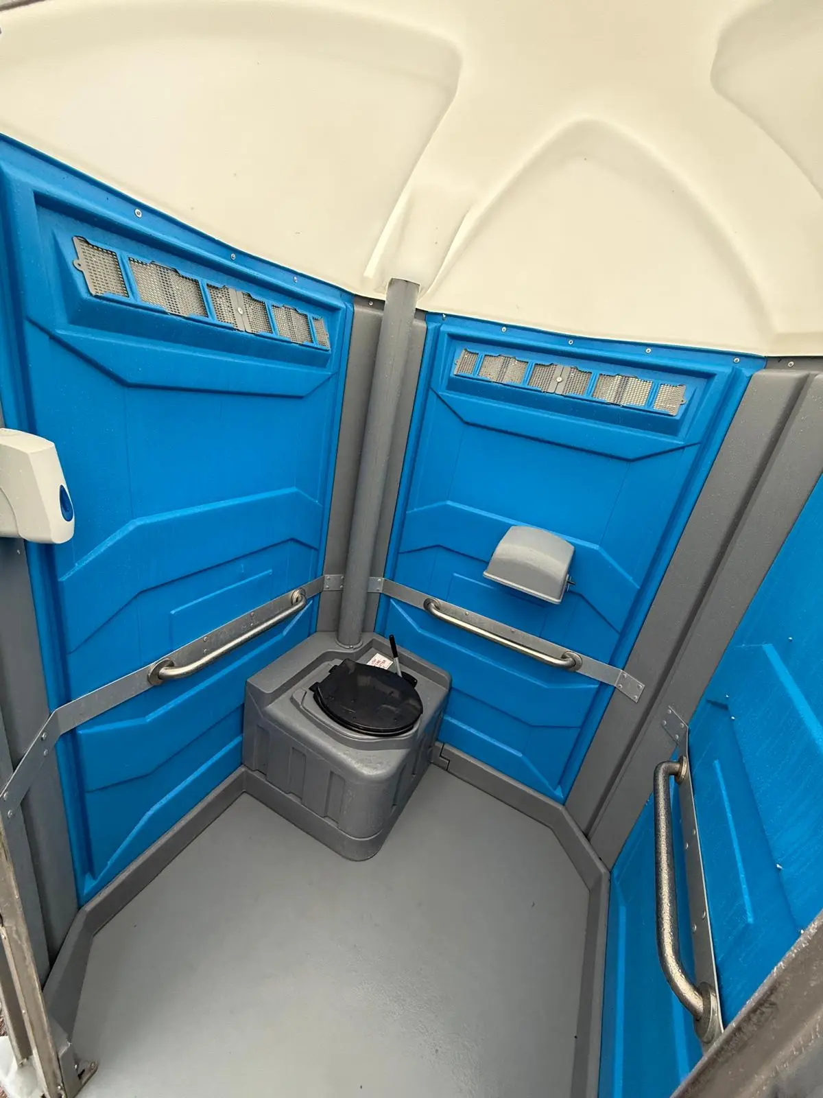 Interior view of disabled toilet showing spacious layout with grab rails and wheelchair turning space